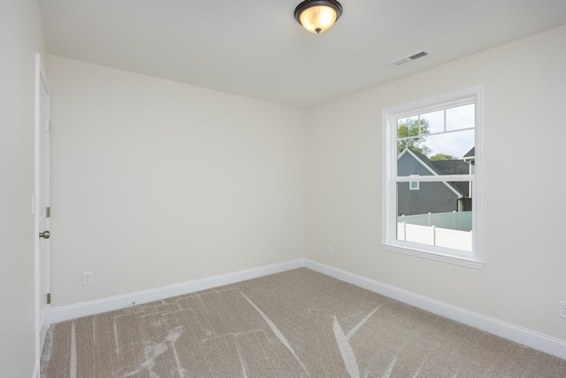 carpeted spare room with baseboards and visible vents