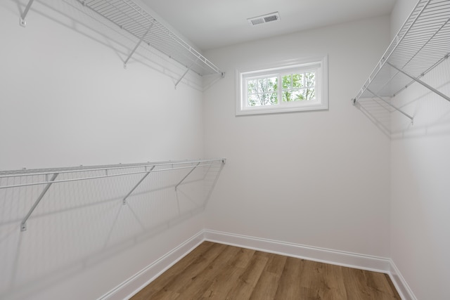 spacious closet featuring wood finished floors and visible vents