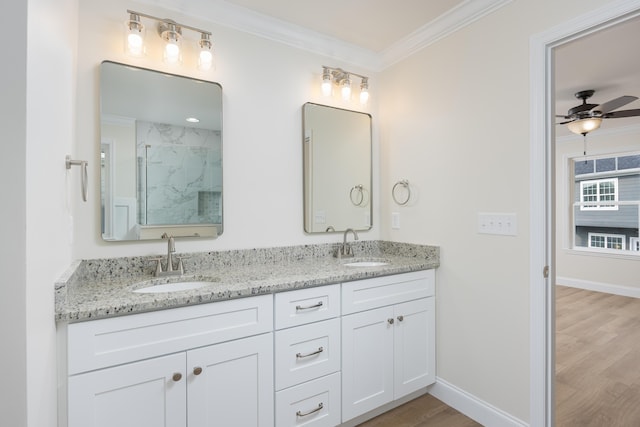 bathroom featuring double vanity, a sink, ornamental molding, and wood finished floors