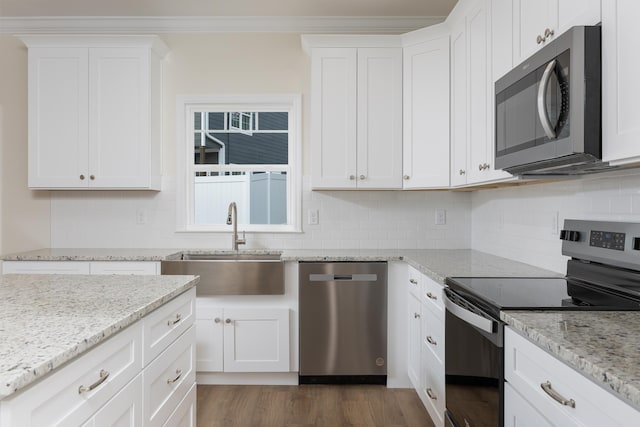kitchen featuring appliances with stainless steel finishes, white cabinetry, dark wood-type flooring, decorative backsplash, and a sink