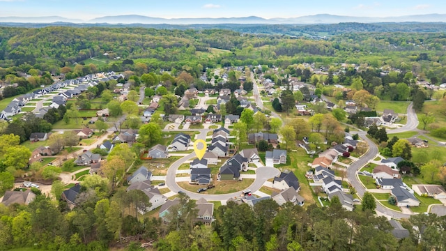 birds eye view of property featuring a wooded view, a residential view, and a mountain view