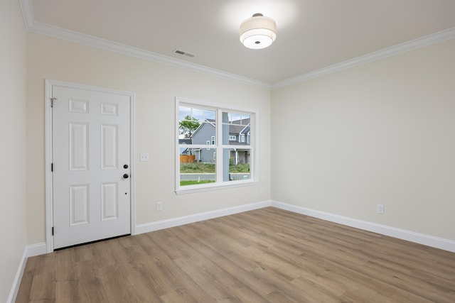 foyer featuring light wood finished floors, visible vents, baseboards, and ornamental molding