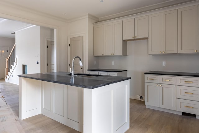 6649 Dharma Loop Unit 119, Chattanooga, TN 37412 - kitchen featuring a sink, light wood-type flooring, dark countertops, and a center island with sink