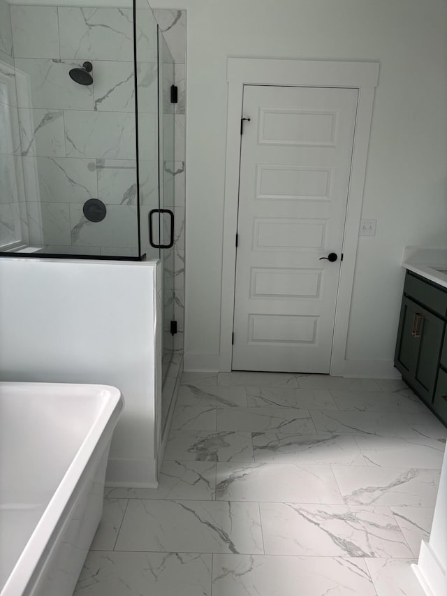 full bathroom with vanity, marble finish floor, a freestanding tub, baseboards, and a shower stall