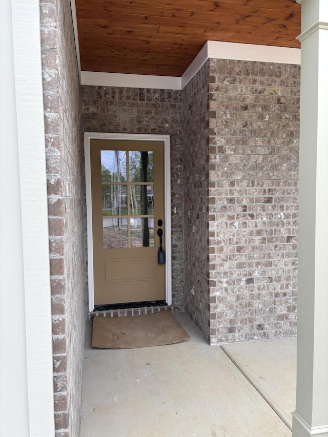 entrance to property featuring brick siding