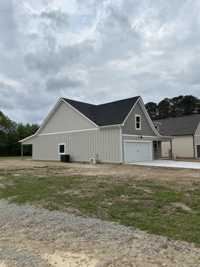 view of side of home featuring central AC unit and driveway