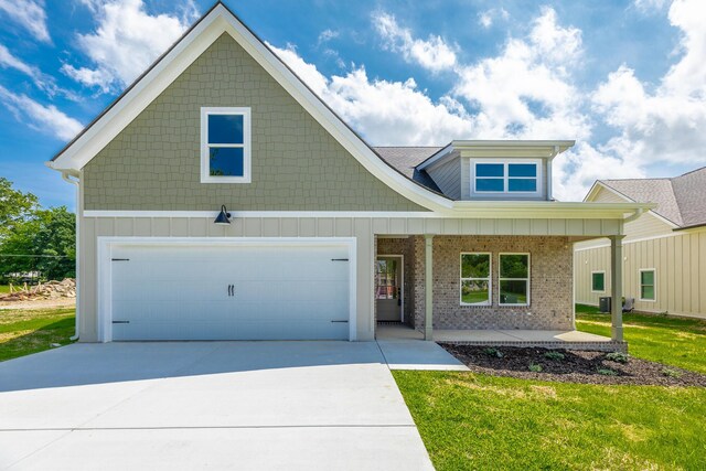 9532 N Valley Trl, Ooltewah, TN 37363 - view of front of house featuring covered porch, driveway, brick siding, a front yard, and a garage