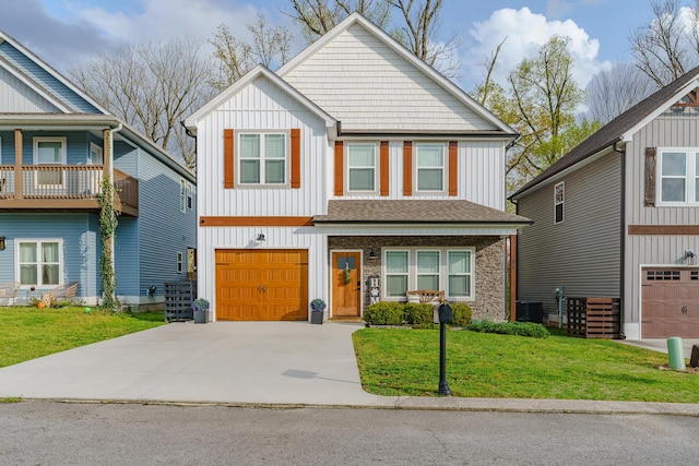 view of front of home featuring board and batten siding, a garage, driveway, and a front lawn