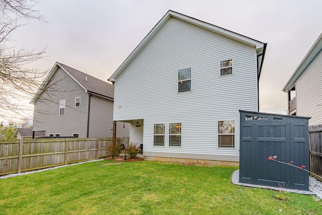 back of house with a storage shed and an outdoor structure