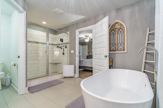 ensuite bathroom featuring a shower stall, ceiling fan, baseboards, and toilet