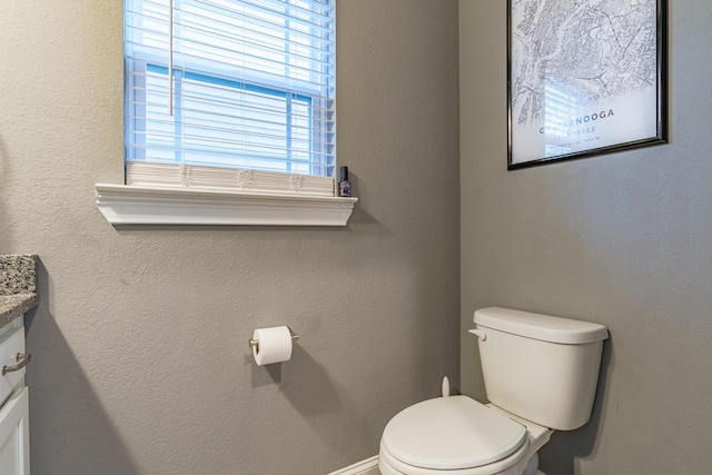 half bathroom featuring toilet and vanity