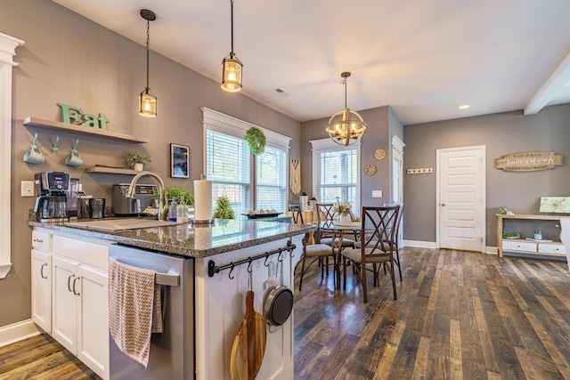 kitchen featuring dark wood-style floors, a chandelier, dishwasher, white cabinetry, and dark stone countertops