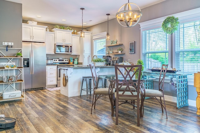 kitchen featuring stainless steel appliances, wood finished floors, a chandelier, white cabinets, and recessed lighting
