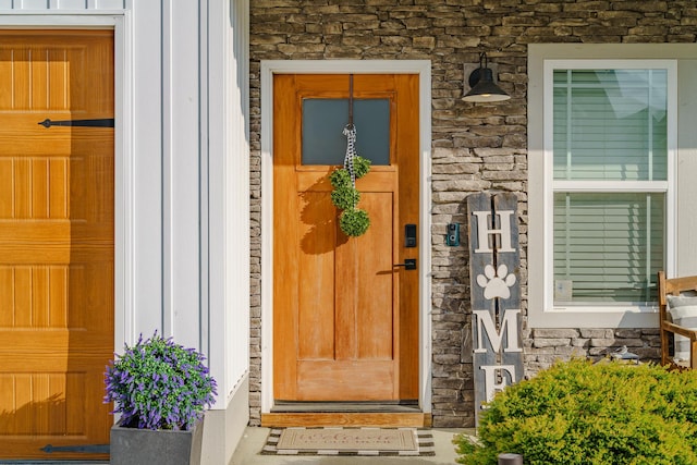 property entrance featuring stone siding and board and batten siding