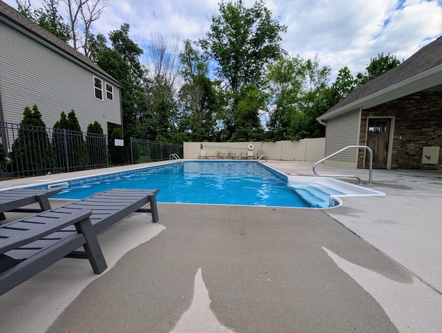view of swimming pool with a patio and fence
