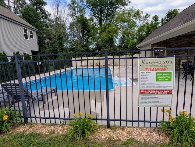 community pool with fence and a patio