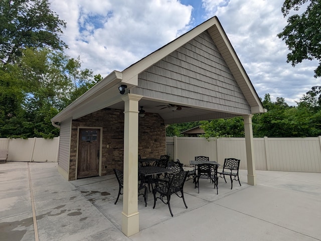 view of patio with ceiling fan, fence, and outdoor dining area