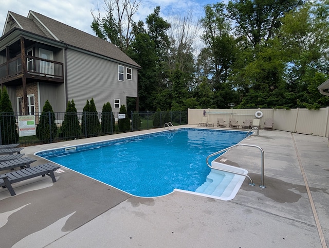 community pool featuring fence and a patio