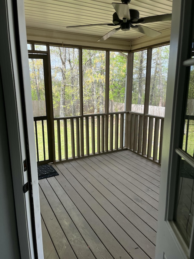 unfurnished sunroom featuring a ceiling fan