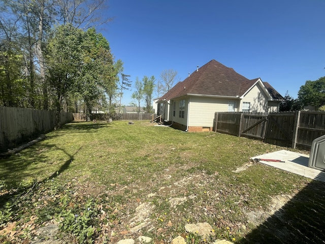 view of yard with a fenced backyard, a patio area, and a gate