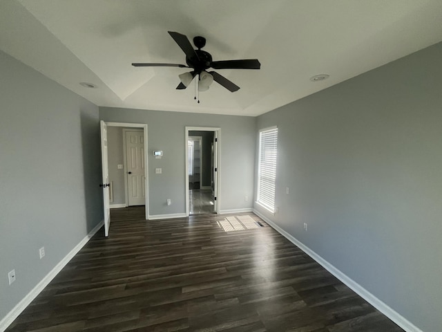 unfurnished bedroom featuring baseboards, a ceiling fan, and dark wood-type flooring