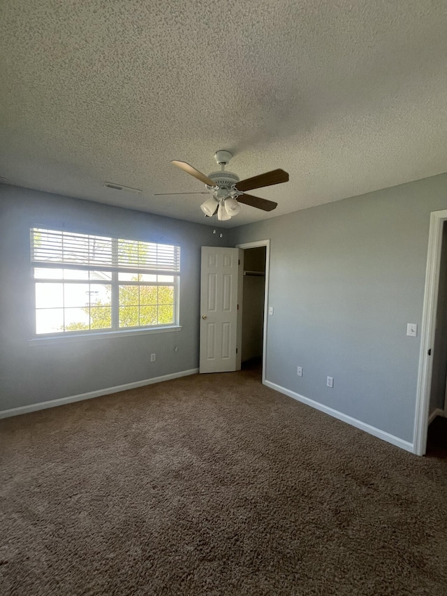unfurnished bedroom with baseboards, a ceiling fan, carpet flooring, and a textured ceiling