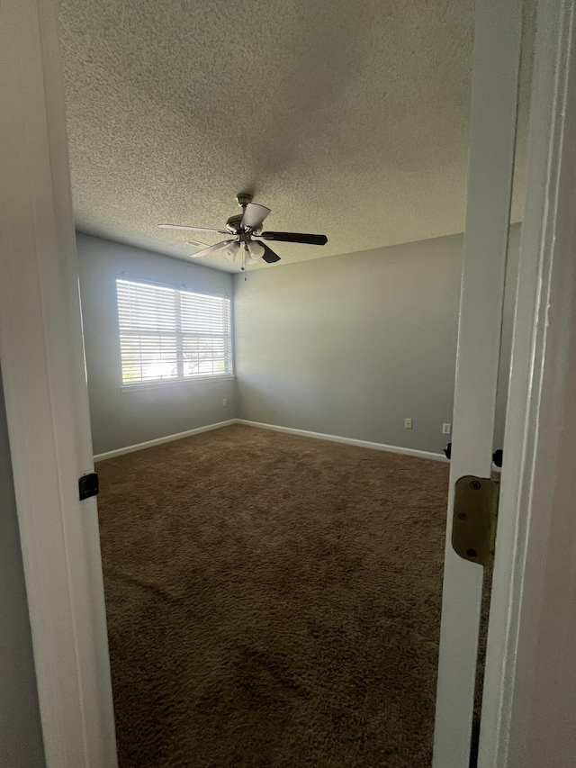 spare room with carpet flooring, a textured ceiling, baseboards, and ceiling fan