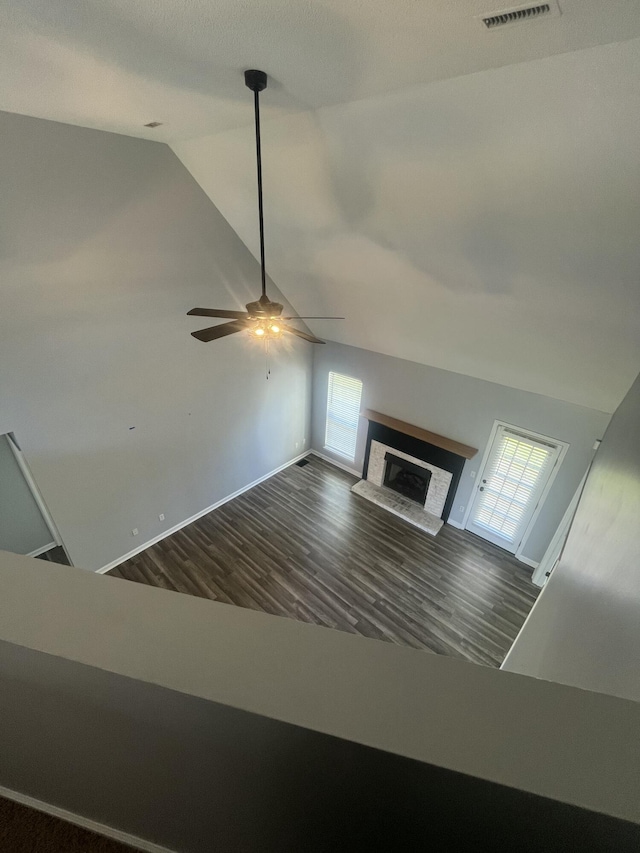 unfurnished living room featuring visible vents, a wealth of natural light, wood finished floors, and lofted ceiling