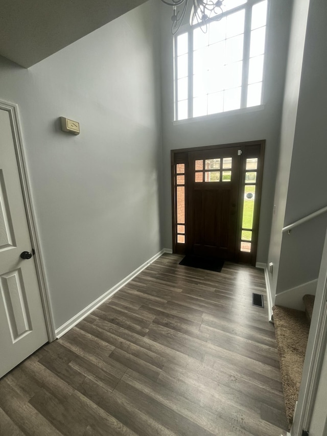 entryway with stairs, dark wood-style flooring, baseboards, and a chandelier