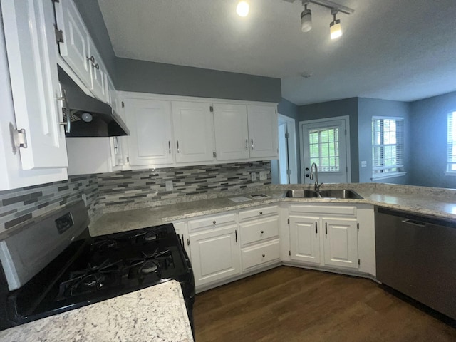 kitchen with white cabinets, a sink, dark wood finished floors, stainless steel appliances, and under cabinet range hood