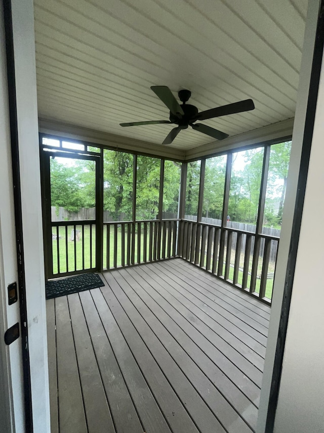 unfurnished sunroom featuring a ceiling fan