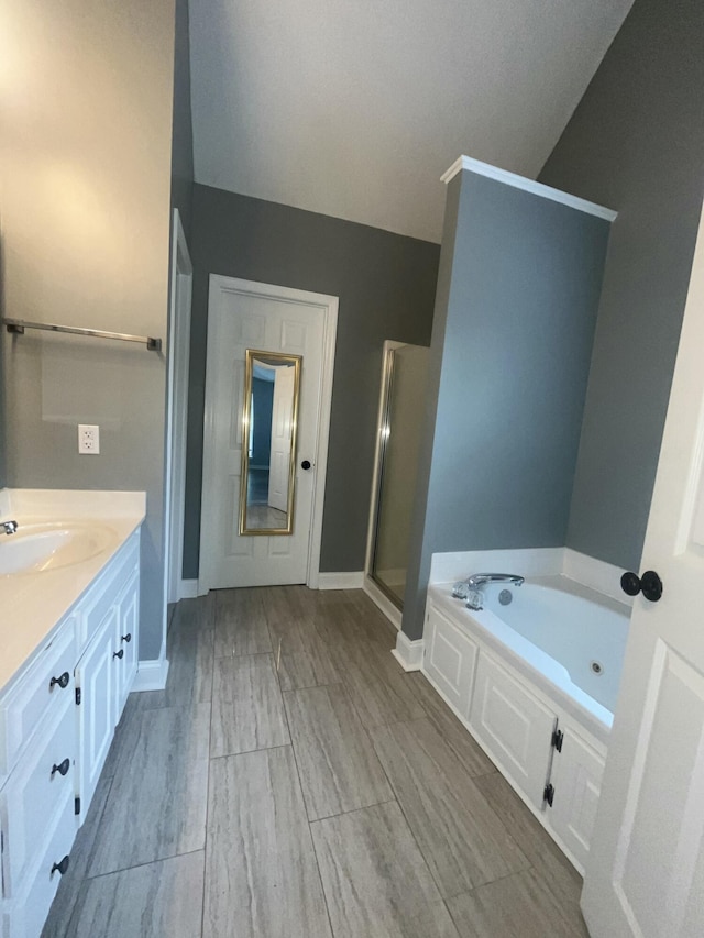 full bath featuring vanity, baseboards, a shower stall, and a bath