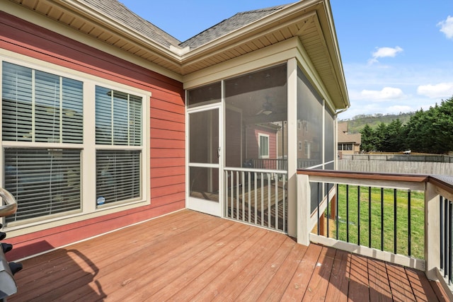 wooden deck with a sunroom and fence