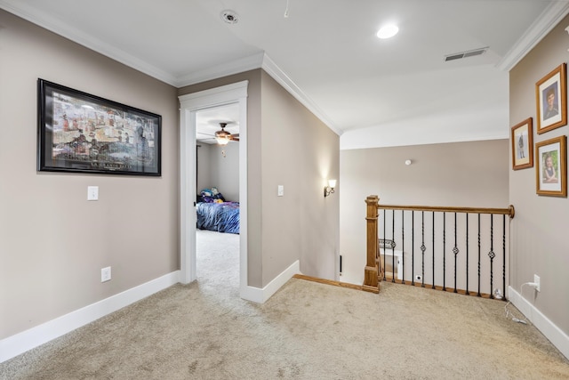 corridor with carpet flooring, visible vents, baseboards, and ornamental molding