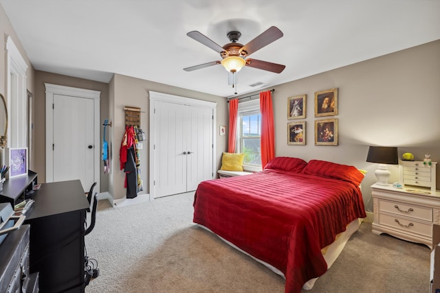 carpeted bedroom with a ceiling fan, a closet, and visible vents
