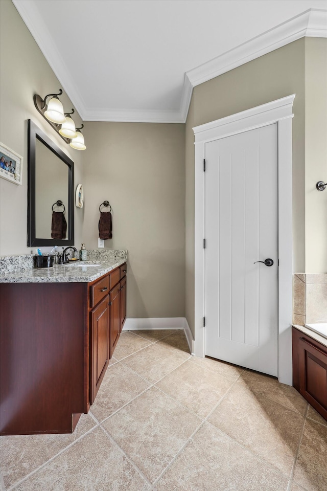 bathroom with vanity, crown molding, and baseboards