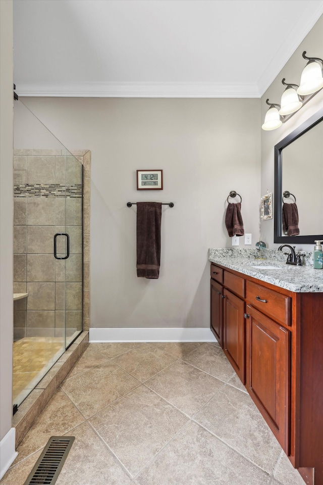 bathroom with a stall shower, vanity, baseboards, visible vents, and ornamental molding