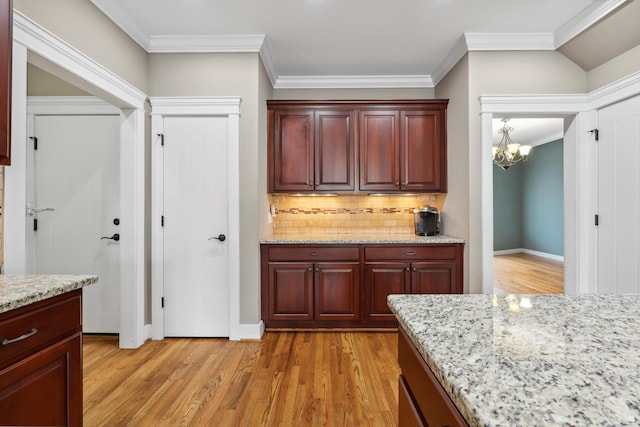 kitchen featuring dark brown cabinets, light wood-style floors, and ornamental molding