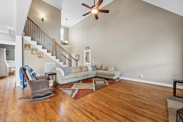 living room with high vaulted ceiling, visible vents, stairs, wood finished floors, and a ceiling fan