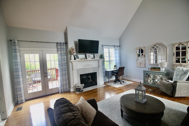 5553 Jonquil Ln, Ooltewah, TN 37363 - living area featuring french doors, high vaulted ceiling, wood finished floors, baseboards, and a tiled fireplace