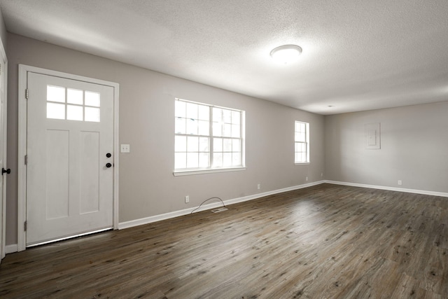 entrance foyer with a textured ceiling, baseboards, and dark wood finished floors