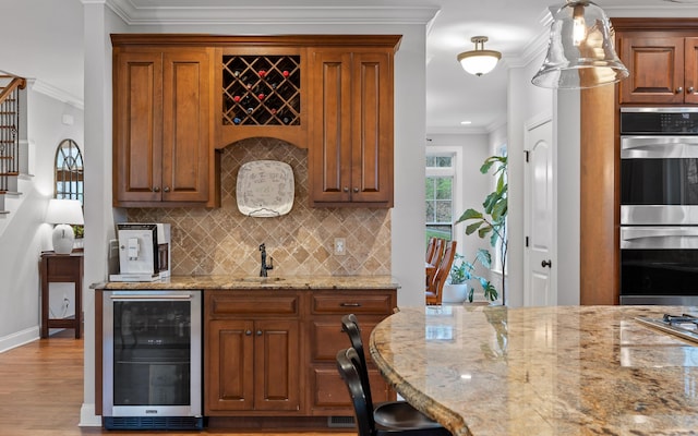 kitchen with ornamental molding, light stone countertops, decorative backsplash, double oven, and beverage cooler
