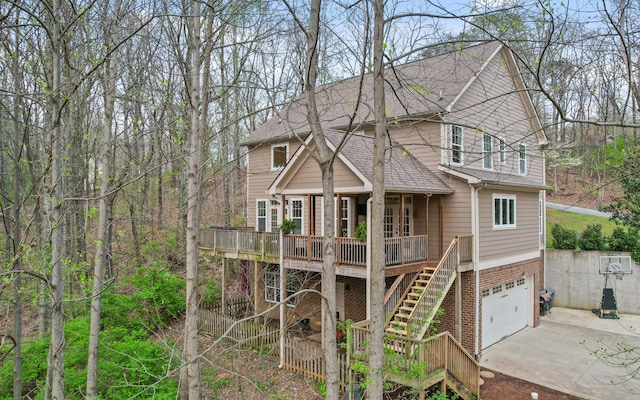 view of front of house featuring roof with shingles, driveway, a garage, and stairs