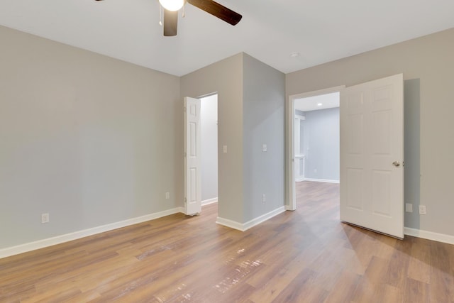 empty room with baseboards, a ceiling fan, and wood finished floors
