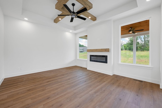 3354 Hawks Creek Dr, Apison, TN 37302 - unfurnished living room with a ceiling fan, a glass covered fireplace, a raised ceiling, wood finished floors, and recessed lighting