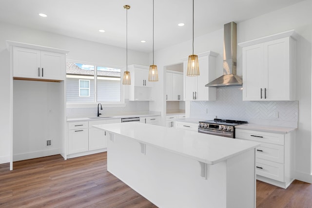 3354 Hawks Creek Dr, Apison, TN 37302 - kitchen with stainless steel stove, wall chimney exhaust hood, a kitchen island, decorative backsplash, and white cabinets