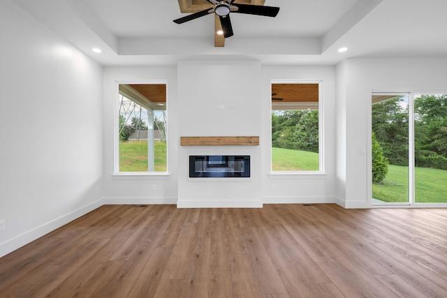 3354 Hawks Creek Dr, Apison, TN 37302 - unfurnished living room featuring wood finished floors, a glass covered fireplace, recessed lighting, ceiling fan, and a raised ceiling