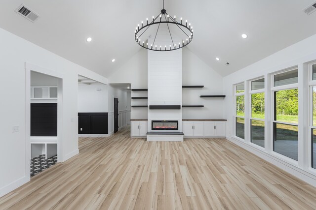 337 Hunter Trl, Trenton, GA 30752 - unfurnished living room featuring light wood finished floors, visible vents, high vaulted ceiling, and a notable chandelier
