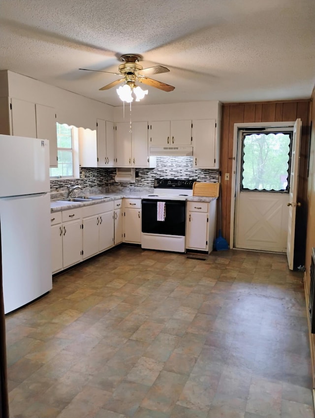 kitchen with white cabinetry, freestanding refrigerator, under cabinet range hood, electric stove, and a ceiling fan