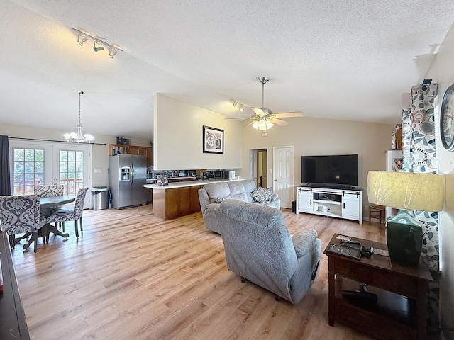 1319 Jacobs Ave, Bridgeport, AL 35740 - living area with ceiling fan with notable chandelier, vaulted ceiling, a textured ceiling, and light wood-type flooring
